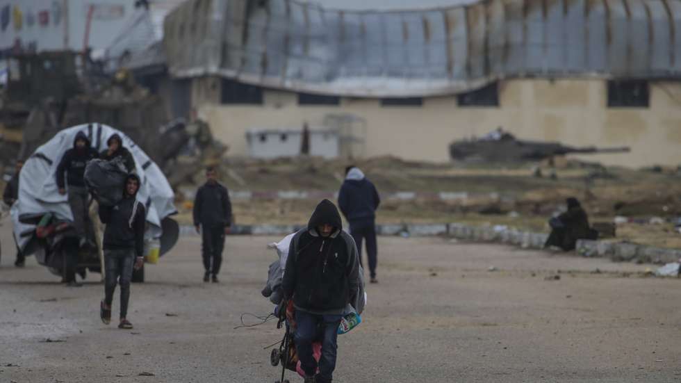 epa11109067 Internally displaced Palestinians move past Israeli tanks after the Israeli army told residents of Khan Yunis camp to leave their homes and head towards Rafah camps near the Egyptian border, southern Gaza Strip, 27 January 2024. Since 07 October 2023, up to 1.9 million people, or more than 85 percent of the population, have been displaced throughout the Gaza Strip, some more than once, according to the United Nations Relief and Works Agency for Palestine Refugees in the Near East (UNRWA), which added that most civilians in Gaza are in 'desperate need of humanitarian assistance and protection'.  EPA/MOHAMMED SABER