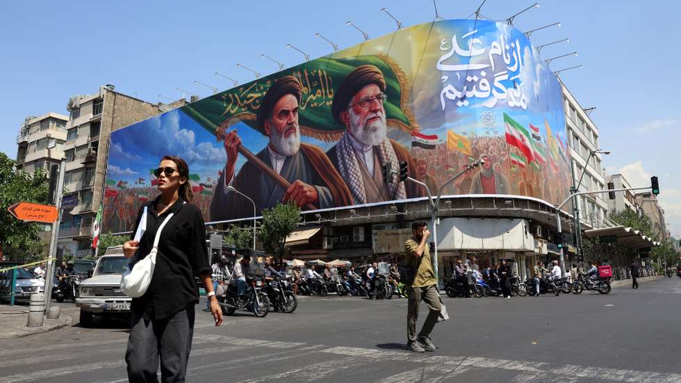 epa13027709 Iranians walk past a large billboard featuring late Iranian Supreme Leader Ayatollah Ruhollah Khomeini and Supreme Leader Ayatollah Ali Khamenei on a street in Tehran, Iran, 10 June 2026. According to US Central Command (CENTCOM), self-defense strikes were carried out against Iran near the Strait of Hormuz on 09 June in response to the downing of a US Army Apache helicopter.  EPA/ABEDIN TAHERKENAREH RESTRICTIONS: NO Access Israel Media/Persian Language TV Stations Outside Iran/Strictly No Access BBC Persian/VOA Persian/Manoto TV/Iran International TV. (As mandated by Iran's Directorate General for Foreign Media) --