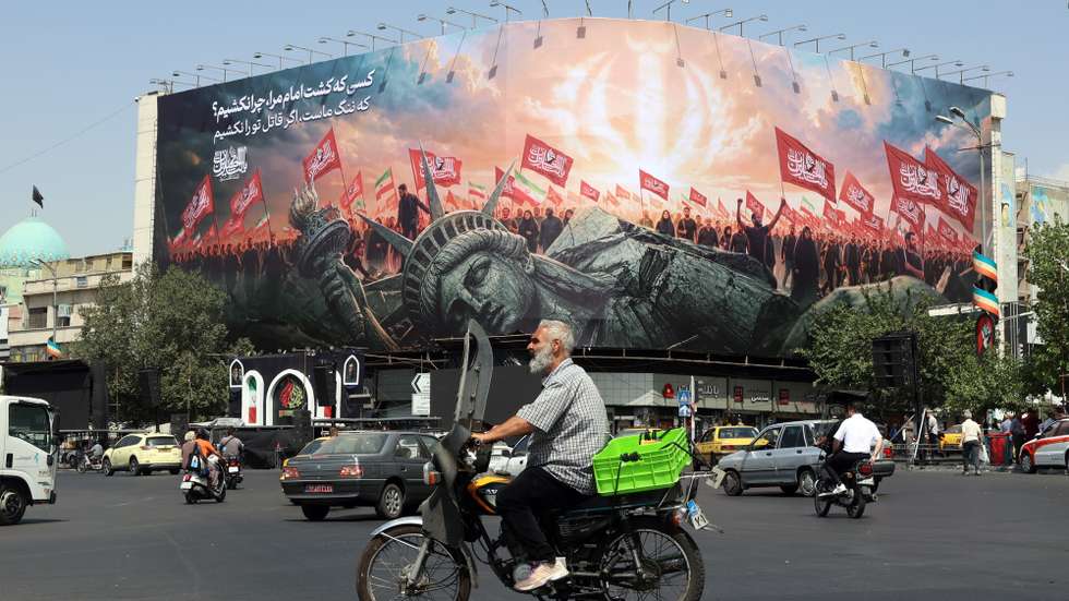 epaselect epa13147977 Iranians drive past an anti-US billboard at Enghelab Square in central Tehran, Iran, 03 August 2026. Tensions between Iran and the US over the Strait of Hormuz continue, as US President Donald Trump said negotiations will take place on 03 August 2026.  EPA/ABEDIN TAHERKENAREH RESTRICTIONS: NO Access Israel Media/Persian Language TV Stations Outside Iran/Strictly No Access BBC Persian/VOA Persian/Manoto TV/Iran International TV. (As mandated by Iran's Directorate General for Foreign Media) --