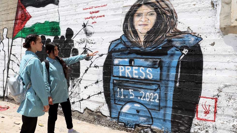 epa09950939 Palestinians walk in front of a mural for Al Jazeera journalist Shireen Abu Akleh in the West Bank city of Bethlehem, 16 May 2022. Al Jazeera journalist Shireen Abu Akleh was killed on 11 May 2022 during a raid by Israeli forces in the West Bank town of Jenin.  EPA/ABED AL HASHLAMOUN
