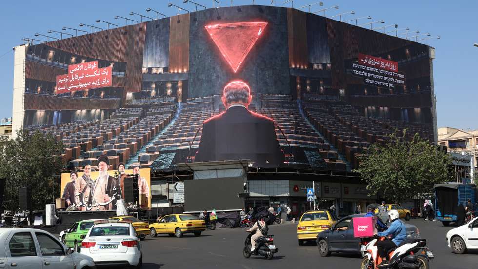 epa13298184 Iranians drive near an anti-Israel billboard featuring Israeli Prime Minster Benjamin Netanyahu and a sentence reading in Persian 'Day by day isolated' at the Enghelab square  in Tehran, Iran, 12 October 2026. The conflict between Iran and the US continues.  EPA/ABEDIN TAHERKENAREH RESTRICTIONS: NO Access Israel Media/Persian Language TV Stations Outside Iran/Strictly No Access BBC Persian/VOA Persian/Manoto TV/Iran International TV. (As mandated by Iran's Directorate General for Foreign Media) --