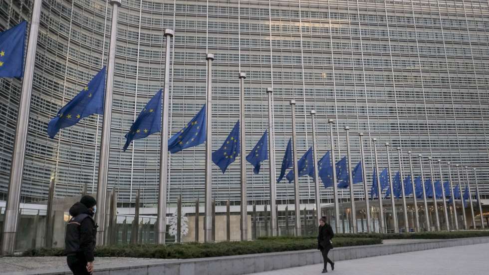 epa09678435 European flags are lowered to half mast in front of the seat of the European Commission in commemoration of late European Parliament President David Sassoli, at EU headquarters in Brussels, Belgium, 11 January 2022. David Sassoli, the Italian journalist who worked his way up in politics and became president of the European Union's parliament, died at a hospital in Italy early 11 January 2022, his spokesperson said.  EPA/OLIVIER HOSLET