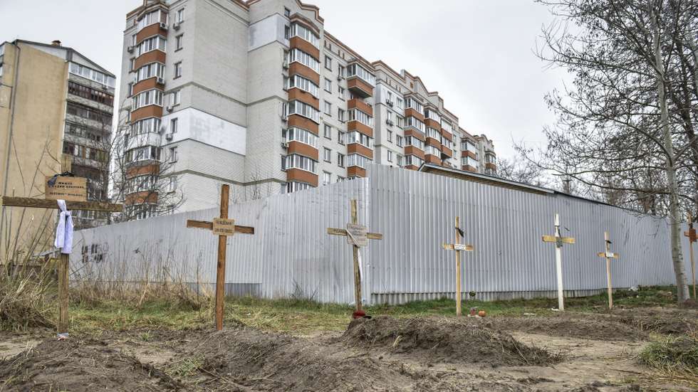 epa09866791 The graves of local citizens, who died during Russian invasion, in front of residential buildings in the areas recaptured by the Ukrainian army in the city of Kyiv (Kiev), Ukraine, 02 April 2022. Dmitrivka and the area around had recently been recaptured by the Ukrainian army from Russian forces. On 24 February, Russian troops had entered Ukrainian territory in what the Russian president declared a 'special military operation', resulting in fighting and destruction in the country, a huge flow of refugees, and multiple sanctions against Russia.  EPA/OLEG PETRASYUK