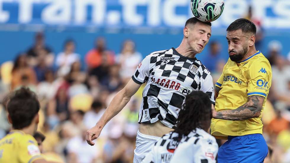 O jogador do GD Estoril Praia Raúl Parra (D) disputa a bola com o jogador do Boavista FC Robert Bozeník (E), durante o jogo da Primeira Liga de Futebol entre o GD Estoril Praia e o Boavista FC, disputado no Estádio António Coimbra da Mota, no Estoril, 03 de setembro de 2023. RODRIGO ANTUNES/LUSA