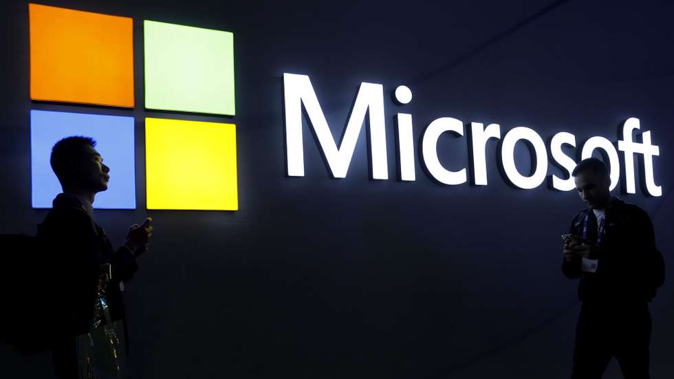 epa11184330 Two visitors walk in front of Microsoft stand during the second day of the MWC (Mobile World Congress) 2024 in Barcelona, Catalonia, north-eastern Spain, 27 February 2024. MWC Barcelona, the largest event for the connectivity ecosystem, will run from 26 to 29 February.  EPA/TONI ALBIR