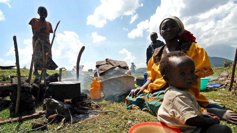 epa00621303 Congolese refugees prepare a simple meal in Kisoro, south west Uganda, Monday, 23 January, 2006. Some 10,000 Democratic Republic of the Congo civilians fled border areas in north Kivu province into Uganda due to unrest between the regular army and local militias. Some of the refugees who came in the last few days went back but others fear that they are going to be forced to leave again as clashes continue. The unrest in the east DR Congo is undermining the peace process that should lead to the first democratic election in the country in April.  EPA/RICKY GARE