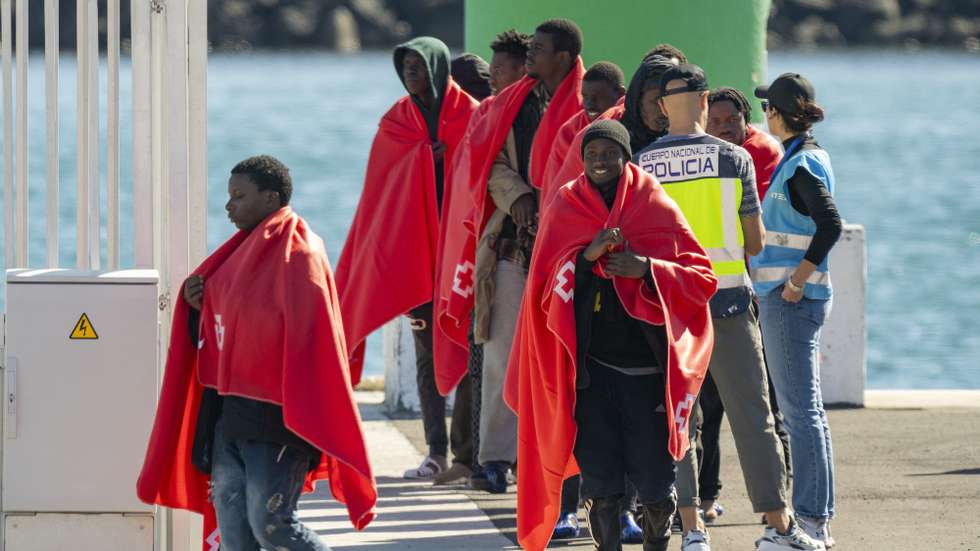 epa11803775 A Spanish police officer (2-R) and a Frontex officer (R) receive migrants upon their arrival at the port of the town of Arrecife, in Lanzarote island, after a boat with over 50 migrants on board was rescued by a Spanish Sea Rescue Unit' ship off Lanzarote island's coast, Canary Islands, southwestern Spain, 03 January 2025.  EPA/Adriel Perdomo