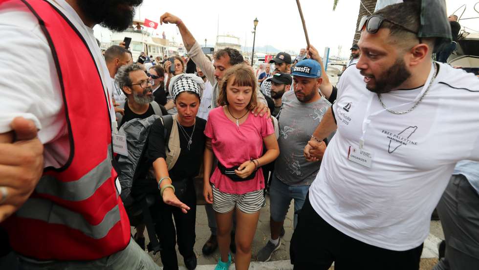 epa12361053 Swedish climate activist Greta Thunberg (C) walks with a crowd of pro-Palestinian activists that arrived to greet the Global Sumud Flottila at the port of Sidi Bou Said, Tunisia, 07 September  2025. The Global Sumud Flotilla will depart from Tunis to Gaza on 10 September as part of a humanitarian effort. The Global Sumud flotilla is an international maritime initiative, launched and led by non-governmental organizations and aim to break the Israeli blockade of the Gaza Strip and deliver vital aid.  EPA/MOHAMED MESSARA 95525