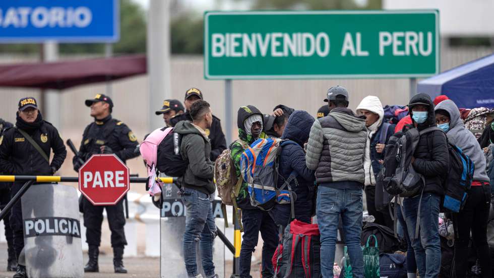epa10611357 Migrants gather at the Chacalluta border crossing before a planned repatriation flight to Venezuela, in Arica, Chile, 05 May 2023.  EPA/Lucas Aguayo Araos
