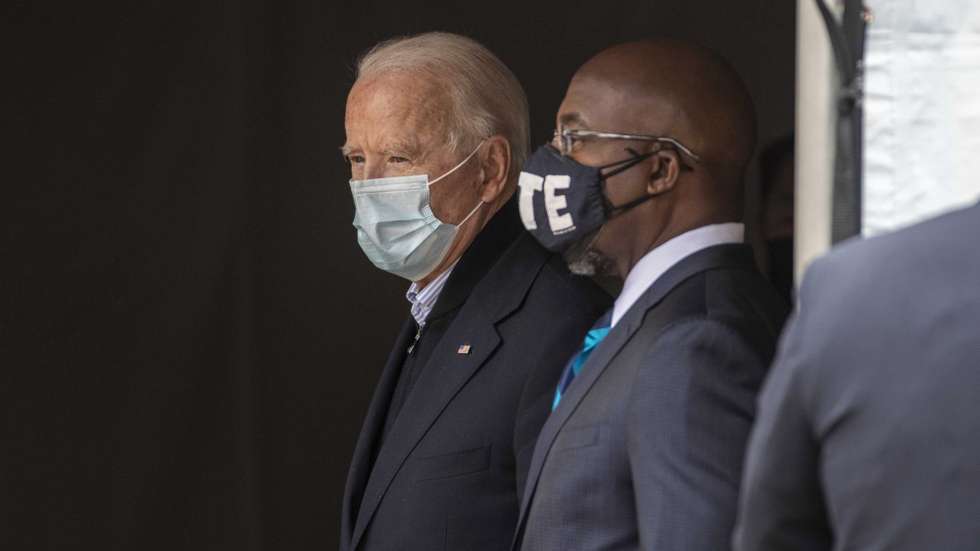 epa08886520 US President-elect Joseph Biden (L) and Democrat Senate candidate Reverend Raphael Warnock (R) speak backstage before speaking during a 'Get Ready to Vote' rally ahead of the Georgia Senate runoff election at Pratt-Pullman Yard in the Kirkwood neighborhood, of Atlanta, Georgia, USA, 15 December 2020. Democrat Reverend Raphael Warnock is running against Republican Senator Kelly Loeffler and Democrat Jon Ossoff is running against Republican Senator David Perdue in a 05 January 2021 runoff election.  EPA/ALYSSA POINTER / ATLANTA JOURNAL CONSTITUTION   EDITORIAL USE ONLY/NO SALES