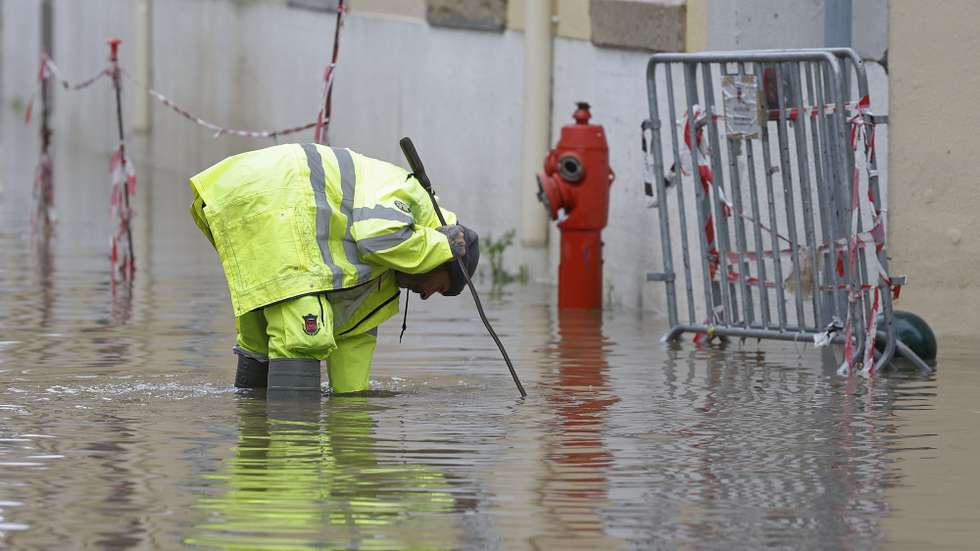 Trabalhadores municipais limpam uma rua inundada após fortes chuvas e o mau tempo sentido esta manhã no distrito de Lisboa causou inundações e afetou o tráfego rodoviário em Alcântara, Portugal, 13 de dezembro de 2022. A proteção civil nacional apelou hoje aos cidadãos para restringirem ao máximo as deslocações por causa do mau tempo, que provocou na noite de hoje 275 ocorrências nos distritos de Lisboa e Setúbal e deverá manter-se até quarta-feira. ANTÓNIO PEDRO SANTOS/LUSA