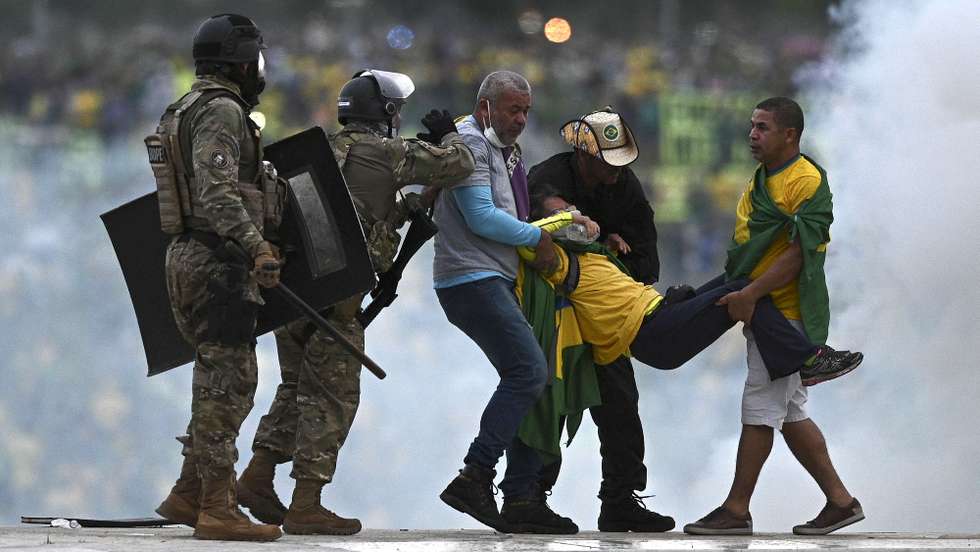 epa10396412 Police confront supporters of former Brazilian President Jair Bolsonaro invading Planalto Palace, in Brasilia, Brazil, 08 January 2023. Hundreds of supporters of former Brazilian President Jair Bolsonaro invaded the headquarters of the National Congress, and also Supreme Court and the Planalto Palace, seat of the Presidency of the Republic, in a demonstration calling for a military intervention to overthrow President Luiz Inacio Lula da Silva. The crowd broke through the cordons of security forces and forced their way to the roof of the buildings of the Chamber of Deputies and the Senate, and some entered inside the legislative headquarters.  EPA/ANDRE BORGES