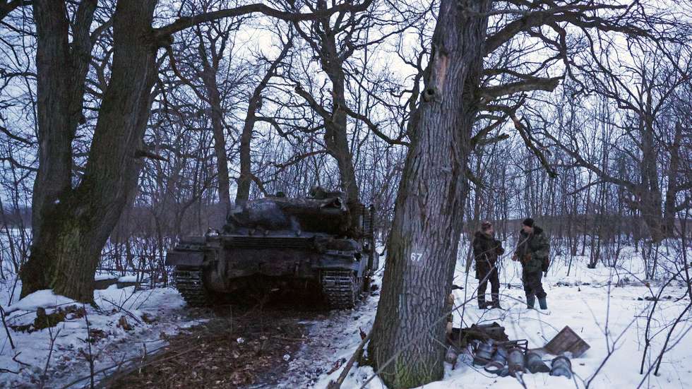 Dois miltares ucranianos conversam junto a um tanque, numa aldeia alvo de bombardeamentos, numa altura em que as tropas russas intensificam os ataques em Bakhmut, cidade decisiva para o controlo da região de Donetsk, em Donbass, 21 de fevereiro de 2023. Um ano após o início da invasão russa da Ucrânia, o balanço é composto por dezenas de milhares de mortos, milhões de refugiados e deslocados internos, cidades bombardeadas e uma economia em colapso. (ACOMPANHA TEXTO DE 22-02-2023) ANTÓNIO PEDRO SANTOS/LUSA