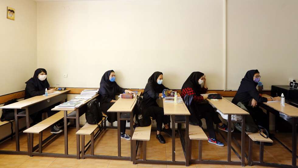 epa08648212 Iranian high school girls wearing face masks attend a class at the Bamdad Parsi private school during the first day of reopening schools, north of Tehran, Iran, 05 September 2020. Media reported that school reopened in Iran during the coronavirus crises in the country.  EPA/ABEDIN TAHERKENAREH