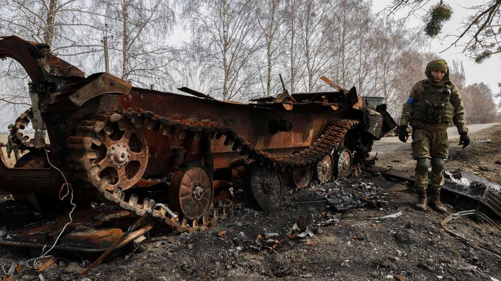 epa09862359 Ukrainian servicemen inspect the remains of a Russian tank that was damaged in the fighting between Ukrainian and Russian forces on a road leading to the Ukrainian city of Makariv, west of Kyiv, Ukraine, 31 March 2022. On 24 February Russian troops had entered Ukrainian territory in what the Russian president declared a 'special military operation', resulting in fighting and destruction in the country, a huge flow of refugees, and multiple sanctions against Russia.  EPA/ATEF SAFADI