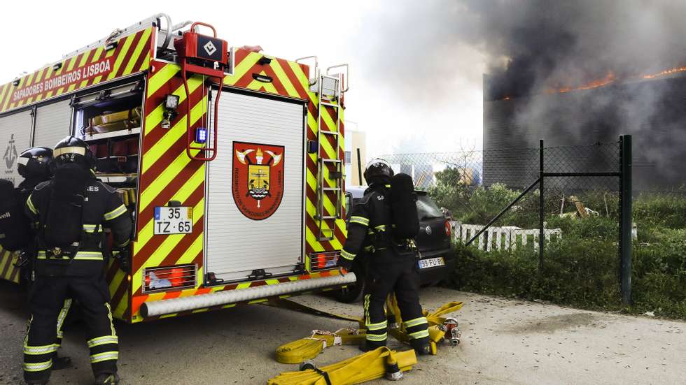 Bombeiros combatem um incêndio que deflagrou hoje ao fim da manhã num armazém de pneus na Azinhaga da Torre do Fato, em Telheiras, Lisboa, 15 de março de 2022. O incêndio levou à evacuação de habitações contíguas, onde já chegou o fogo. JOÃO RELVAS/LUSA