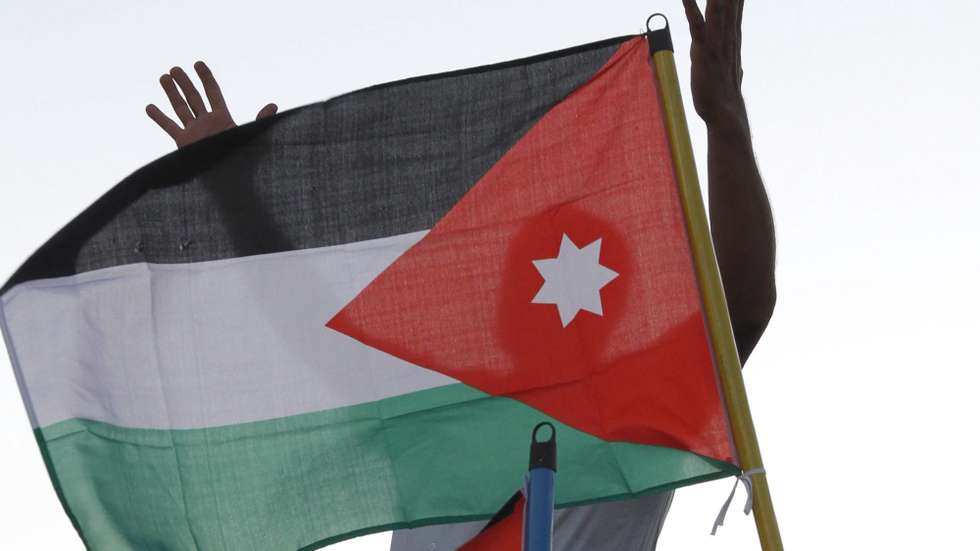 epa02918316 A Jordanian protester shouts anti-Israeli slogans behind a Jordanian flag as hundreds of Jordanians protest near Israeli embassy in Amman, Jordan, 15 September 2011. Israel evacuated its embassy in Amman late 14 September night, after calls by Jordanian activists for a 'million man march' near the embassy building.  EPA/JAMAL NASRALLAH