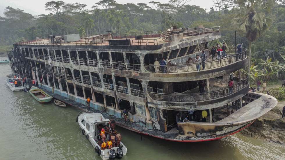 epa09655641 Firefighters and coast guards shift body bags of victims after a passenger ferry caught fire near the southern rural town of Jhalakathi,  south of Dhaka in Bangladesh, 24 December 2021. At least 36 people died after a ferry caught fire on the Sugandha River in southern Bangladesh near Jhalakathi Sadar upazila early Friday in Bangladesh, according to Police and Fire service.  EPA/STR