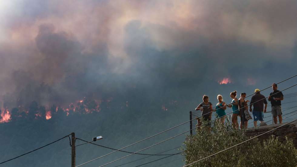 Habitantes observam o incêndio na aldeia de Sameiro, na encosta Norte da Serra da Estrela, Covilhã, 9 de agosto de 2022. Este incêndio deflagrou no sábado na localidade de Garrocho, no concelho da Covilhã (Castelo Branco), continua ativo e está a ser combativo por 680 operacionais, apoiados por 205 viaturas e 13 meios aéreos. MIGUEL PEREIRA DA SILVA/LUSA