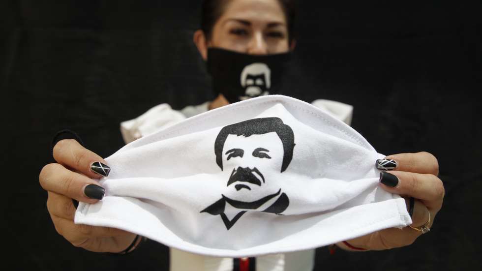 epa08367814 A person holds a face mask, which depicts famed drug lord Joaquin 'El Chapo' Guzmanto, in Guadalajara, Jalisco, Mexico, 16 April 2020. According to media reports, Alejandrina Guzman, daughter of Joaquin 'El Chapo' Guzman, has helped in the distribution of aid and supplies, labelled with the name and image of her father, to members of the public during the outbreak of coronavirus in Mexico.  EPA/Francisco Guasco