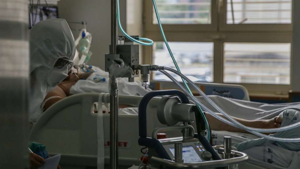 Uma enfermeira cuida de um paciente hospitalizado na Unidade de Cuidados Intensivos Covid 19 do Hospital Santa Maria em Lisboa, 27 de outubro de 2020. A urgência dedicada aos casos suspeitos de covid-19 do Hospital Santa Maria, em Lisboa, reflete a evolução da pandemia em Portugal com doentes a avolumarem-se à porta para realizar o teste e no interior a capacidade quase esgotada. O medo de perder o emprego leva muitos doentes com covid-19 a esconderem que estão infetados e a continuar a trabalhar, disseminando a doença que, nesta fase, começa a ser um caso também social e que leva a muitos internamentos no Santa Maria. (ACOMPANHA TEXTO DA LUSA DE 30 DE OUTUBRO DE 2020) TIAGO PETINGA/LUSA