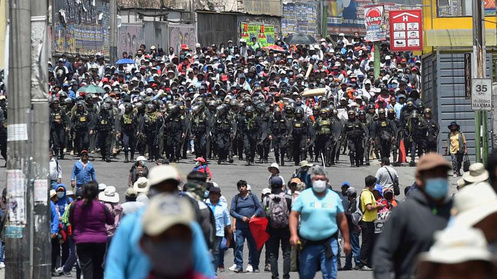 epa10365706 Police officers watch over a demonstration by supporters of deposed President Pedro Castillo, in Arequipa, Peru, 14 December 2022. The Peruvian Government declared on 14 December a state of emergency throughout the country for 30 days, which implies the suspension of assembly rights, inviolability of the home and freedom of transit, among others, while evaluating the possibility of declaring a curfew.  EPA/JOSE SOTOMAYOR