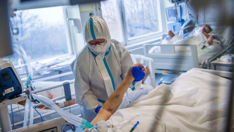 epa08879496 A physiotherapist wearing protective gear works with a patient at the intensive care unit of National Koranyi Institute of Pulmonology treating COVID-19 patients, during the pandemic of new coronavirus COVID-19 in Budapest, Hungary, 11 December 2020.  EPA/ZOLTAN BALOGH HUNGARY OUT