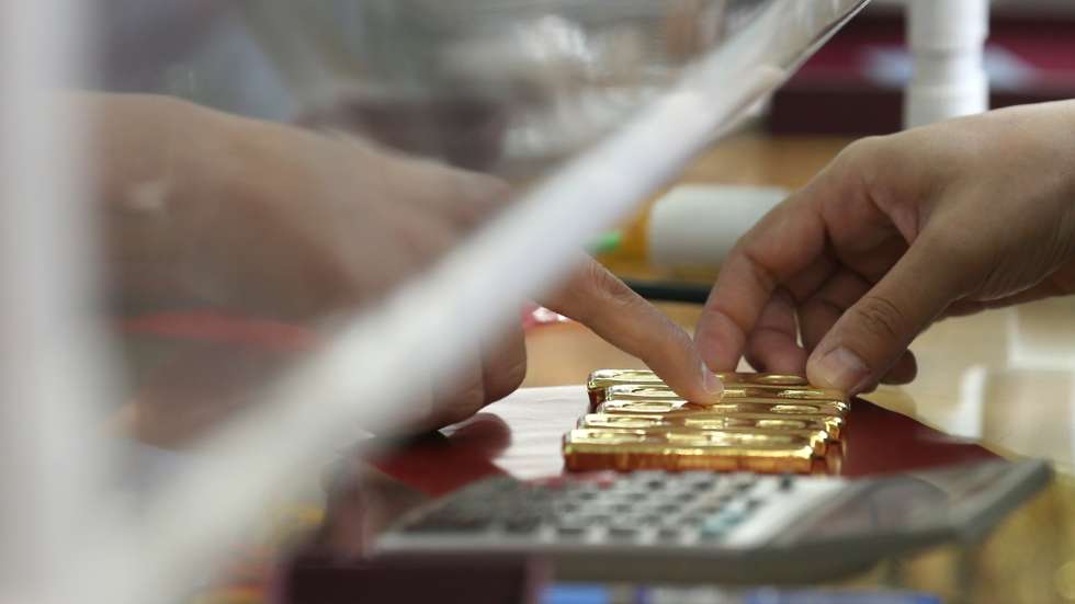epa08589065 A seller (R) checks gold bars at a gold shop in Chinatown, Bangkok, Thailand, 07 August 2020. People flocked to sell their ornaments after the price of gold rose sharply over 30,000 Thai baht (962.44 US dollar) per baht-weight for gold bars on 06 August 2020. According to the Thai Gold Traders Association, it is the highest gold price since February 2012.  EPA/NARONG SANGNAK