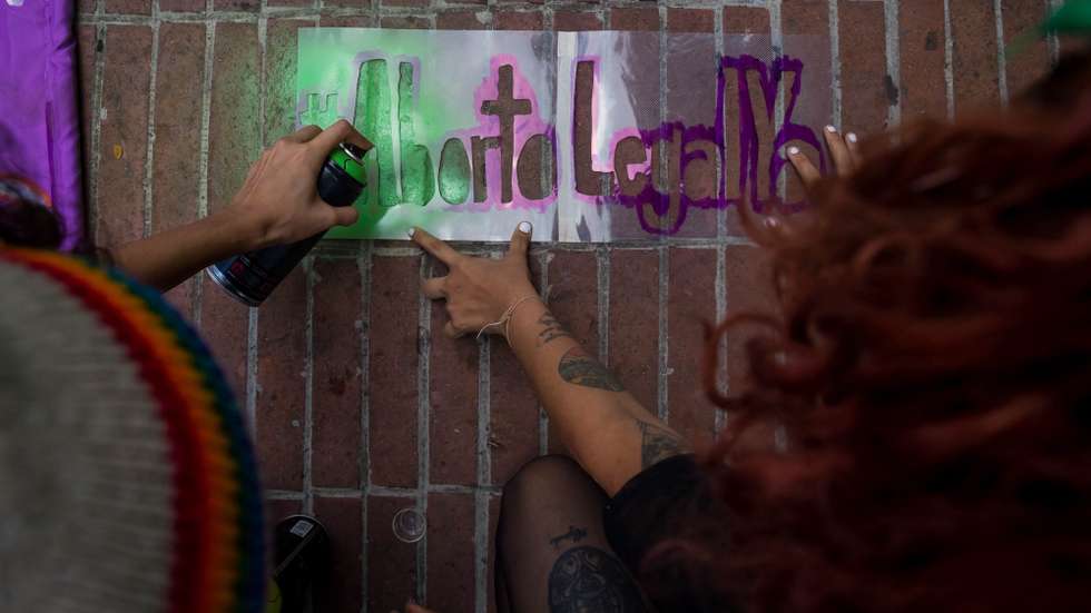 epa09494528 Two young people paint graffiti during a demonstration to demand legal abortion, within the framework of the Global Day of Action for Legal and Safe Abortion, in Caracas, Venezuela, 28 September 2021. About a hundred people marched in Caracas to demand the decriminalization of abortion in Venezuela and demand that Parliament promote a legal, cultural, and social agenda to debate the issue, at the proposal of some ten feminist organizations. Legal abortion is a historical vindication of feminist groups in Latin America, where only Argentina, Cuba, Uruguay, Guyana and four states of Mexico have decriminalized it.  EPA/Miguel Gutierrez