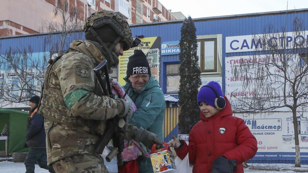 epa10397091 A Ukrainian serviceman hands candies to a girl at a street of Bakhmut, Donetsk region, eastern Ukraine, 09 January 2023, amid Russia's invasion. For months the front-line city of Bakhmut has seen heavy fighting taking place as it has been a key target for Russian forces. Russian troops on 24 February 2022, entered Ukrainian territory, starting a conflict that has provoked destruction and a humanitarian crisis.  EPA/MYKOLA TYMCHENKO