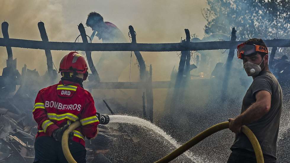 Bombeiros combatem o fogo que destruiu um barracão de lenha junto a uma casa em Macieira, durante o incêndio que começou em Abiul, Pombal, na passada sexta-feira, Macieira, Alvaiázere, 14 de julho de 2022. PAULO NOVAIS/LUSA