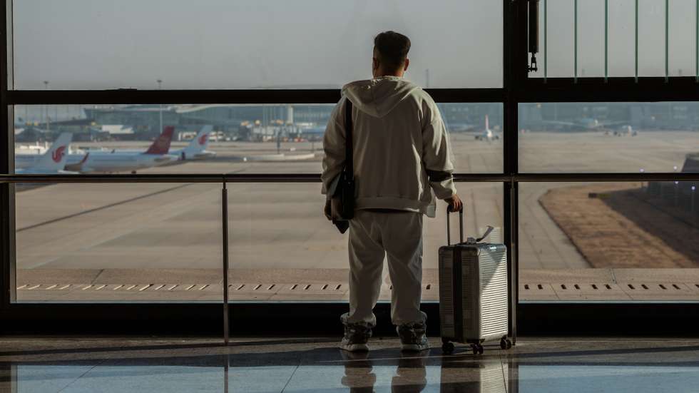 epa10395516 A man stands looking trough the window on the Pudong International Airport, in Shanghai, China, 08 January 2023. China has reopened its borders and no longer requires quarantine for inbound travellers. The country's National Health Commission (NHC) has downgraded the management of COVID-19 from Class A to Class B as part of measures in reopening the country.  EPA/ALEX PLAVEVSKI