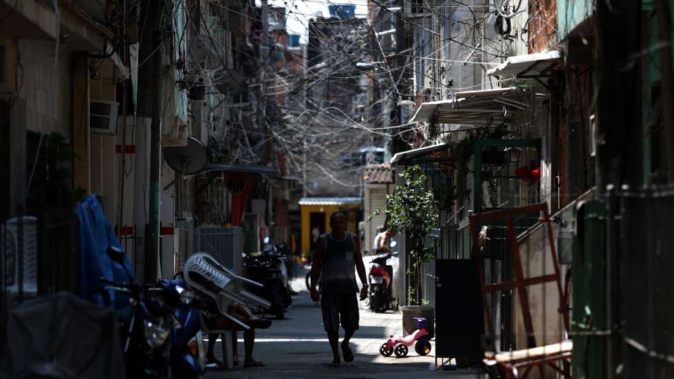 epa08747820 A man walks in the Mare favela, in Rio de Janeiro, Brazil, 13 October 2020 (issued 15 October). The streets returned to their dynamics in Mare. In the midst of crowded commerce and traffic congestion, this complex of favelas in Rio de Janeiro is experiencing a &quot;new normal&quot; in the midst of a pandemic. Poverty and violence remain, but solidarity is now more visible.  EPA/FABIO MOTTA