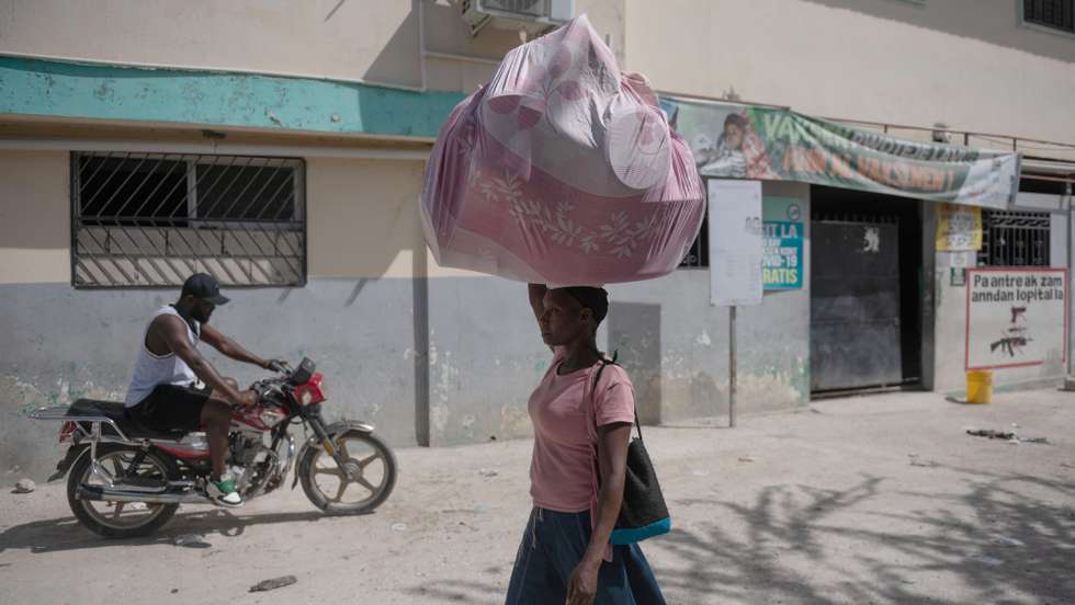epa10979999 A woman walks in front of the hospital in the populous neighborhood of Cite-Soleil, a sector marked by new clashes between groups fighting for control of new neighborhoods, in Port-au-Prince, Haiti, 16 November 2023. Haiti is awaiting the deployment of a multinational United Nations mission, which Kenya will lead. The Kenyan Parliament approved the deployment of a thousand police officers in Haiti as part of a multinational UN mission, requested on several occasions by the Prime Minister, Ariel Henry, in the midst of a crisis marked by the extreme violence of gangs, which has caused hundreds of murders, rapes, kidnappings and other crimes.  EPA/Johnson Sabin