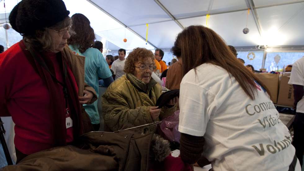 Uma voluntária oferece roupa durante a 24.ª Festa de Natal da Comunidade Vida e Paz realizada na Cantina da Cidade Universitária, Lisboa, 14 de Dezembro de 2012.  ANTONIO COTRIM/LUSA