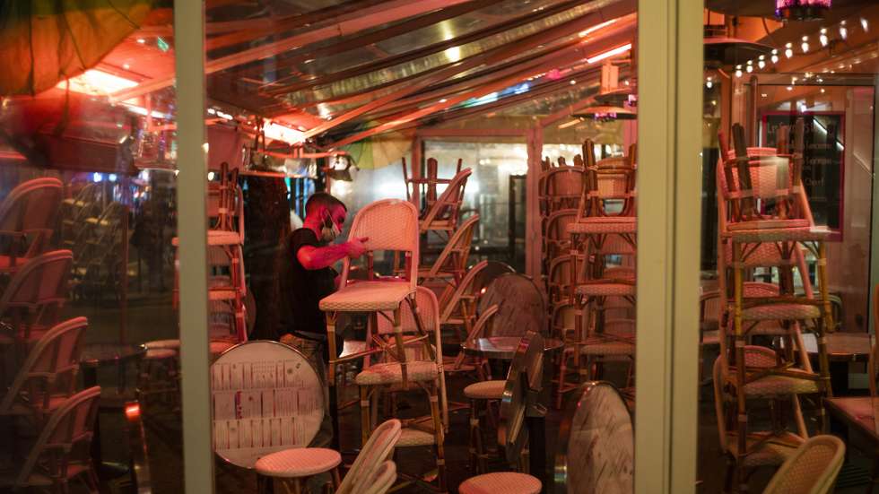 epa08754306 A waiter cleans a bar terrace just minute before a city-wide night time curfew goes into effect in Paris, France, 17 October 2020. French President Emmanuel Macron announced on 14 October that a curfew would be established for a minimum duration of four weeks in Paris and eight other cities across France to reduce the spread of COVID-19 after a surge in cases of coronavirus across the country. The curfew prohibits leaving one's house between 9pm and 6am unless a valid motive is presented.  EPA/YOAN VALAT