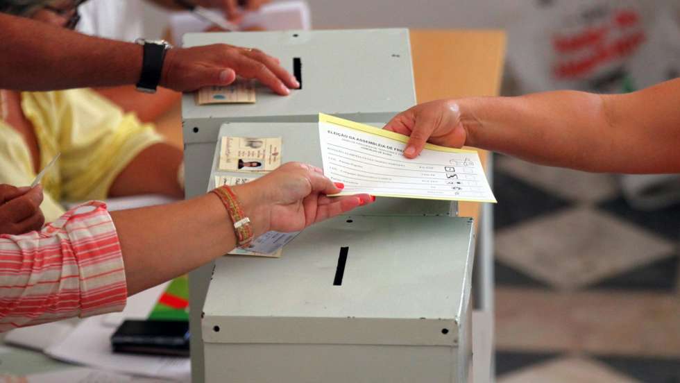 Uma eleitora recolhe os boletins de voto para cumprir o seu direito cívico numa mesa de voto