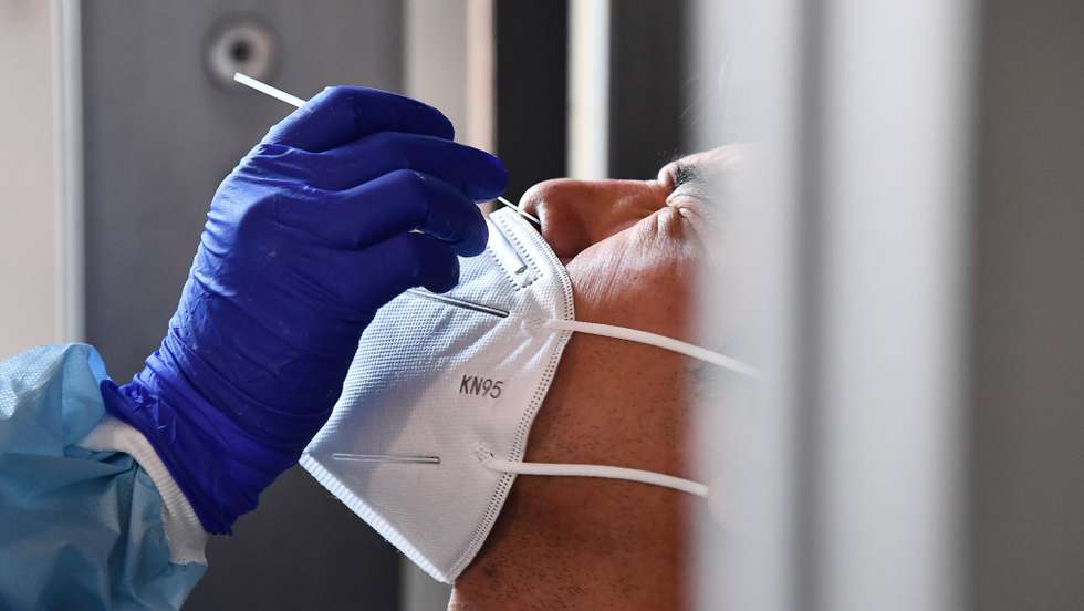 epa08818243 A health worker of Asl 3 (Local Health Company) collects a nose swab sample for a polymerase chain reaction (PCR) test at Siberia Door, one of the historic gates to enter the city of Genoa, in the middle of town, set up for free coronavirus testing facility during the coronavirus disease COVID-19 outbreak, in Genoa, Italy, 13 November 2020.  EPA/LUCA ZENNARO
