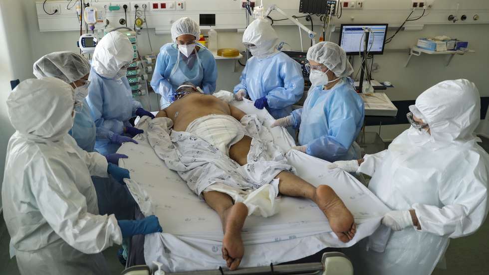 Dois elementos da equipa médica cuidam de um paciente hospitalizado na Unidade de Cuidados Intensivos covid-19 do Hospital Santa Maria, em Lisboa, 11 de fevereiro de 2021. O Hospital Santa Maria conta ao dia de hoje com 271 doentes internados com  64 destes doentes internados nos Cuidados Intensivos covid-19, o número máximo atingido até ao dia de hoje neste Hospital. (ACOMPANHA TEXTO DA LUSA DO DIA 14 DE FEVEREIRO DE 2021). MIGUEL A. LOPES/LUSA