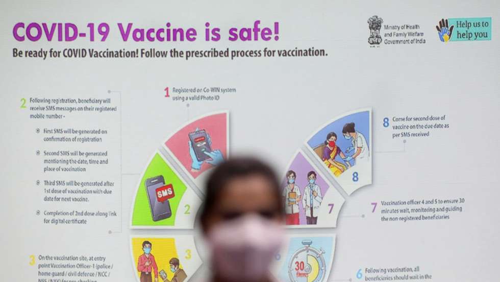 epa08925734 A doctor waits near a vaccination guideline poster in a Covid-19 vaccination centre during a second phase of mock vaccinations in Kolkata, India, 08 January 2021. Drug Controller General of India (DCGI) has approved the emergency use of coronavirus vaccine developed by AstraZeneca and Oxford University. India is the world's second-hardest hit nation by the coronavirus disease pandemic.  EPA/PIYAL ADHIKARY