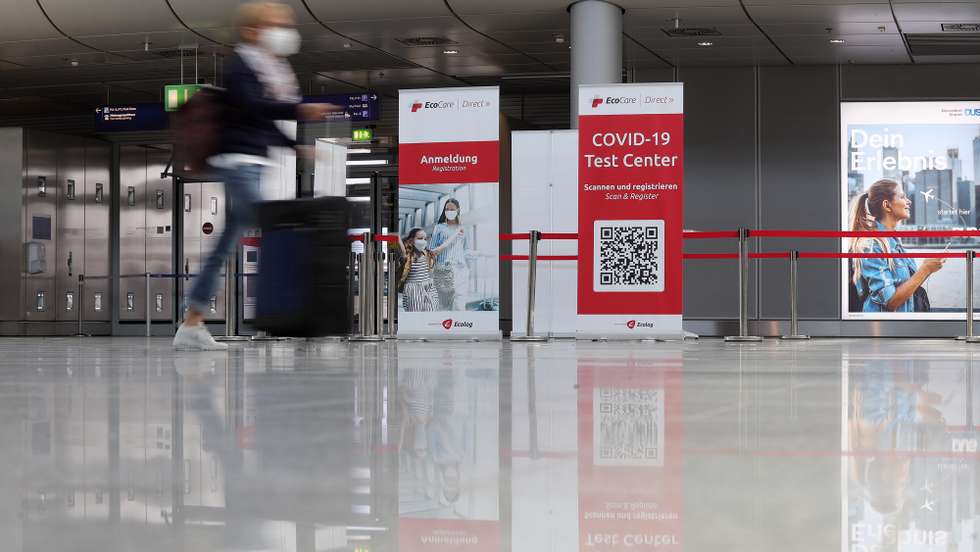 epa09099196 A passenger walks past a sign for the coronavirus test center at the Dusseldorf International Airport in Dusseldorf, Germany, 26 March 2021. German tourist are set to travel to the Spanish island of Mallorca over the Easter holiday season after popular tourist destination was taken off Germany's list of coronavirus 'risk areas.'  EPA/FRIEDEMANN VOGEL