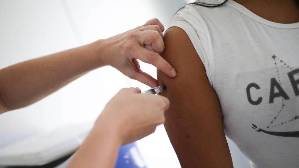 epa09377220 A person receives a dose of the vaccine against covid-19 during an immunization day for residents of the Mare favela complex, at the Adib Jatene family clinic, in Rio de Janeiro, Brazil, 29 July 2021. More than 30,000 people will be vaccinated in the largest complex of favelas in Rio de Janeiro as part of a study that seeks to measure the direct and indirect effectiveness of immunization in these types of communities. La Mare began the first day of mass vaccination against covid on 29 July, an experiment never seen before in a community of this style in Brazil.  EPA/Andre Coelho