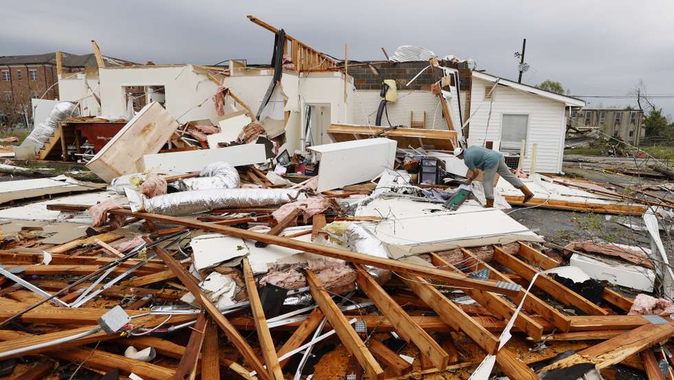 epa09099375 Tommy Sweet sifts through debris from a building he owns after an apparent tornado swept through Newnan, Georgia USA, 26 March 2021. The spring severe weather outbreak left at least six people dead in Alabama and Georgia.  EPA/ERIK S. LESSER