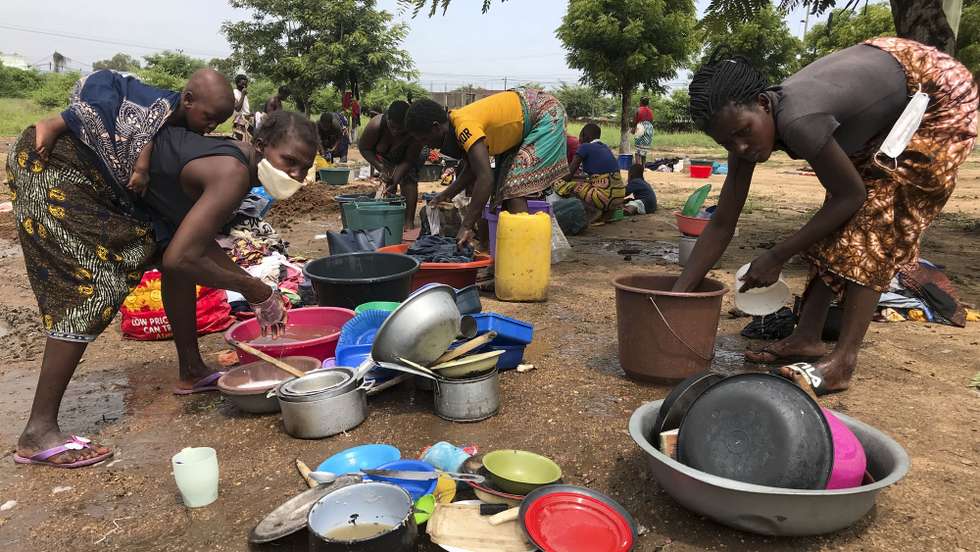 Mulheres lavam os seus pertences no Instituto Industrial de Tete, após a passagem da tempestade tropical Ana, em Tete, Moçambique, 27 de janeiro de 2022. A intempérie atingiu diretamente o país entre segunda e quarta-feira, mas apesar de já ter enfraquecido e avançado para outros países (Zimbabué e Zâmbia), as chuvas intensas alimentaram o caudal de todos os rios no centro e norte de Moçambique, que continuam a provocar inundações. ANDRÉ CATUEIRA/LUSA