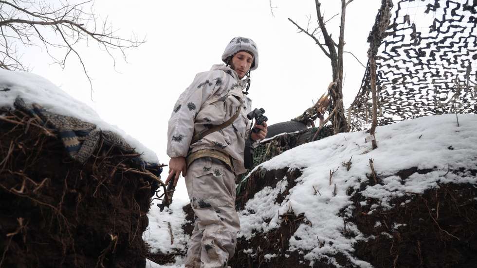 Um soldado ucraniano verifica a situação nas posições da linha da frente, não muito longe de onde os militares russos controlam a cidade de Horlivka, Ucrânia, 31 de janeiro de 2022
