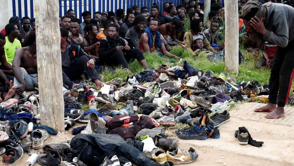 epaselect epa09357670 Several migrants rest after they managed to reach Spain by jumping the border fence with Morocco, in Melilla, a Spanish enclave in northern Africa, 22 July 2021. Some 300 migrants managed to reach Spain after they massively jumped the border fence in the early morning.  EPA/PAQUI SANCHEZ