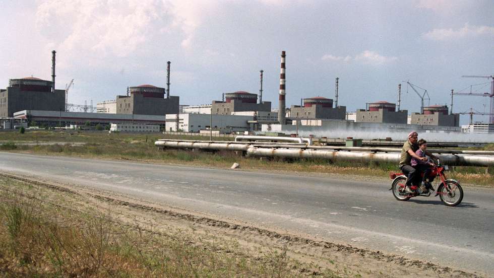epaselect epa09800552 (FILE) - A man with a boy on a scooter pass Zaporozhskaya Nuclear power station, Ukraine, 09 March 1994 (reissued 04 March 2022). Zaporizhzhia, the largest nuclear power plant in Europe, was set on fire after shelling by Russia early 04 March 2022. The fire was extinguished by state emergency service workers. Russian troops entered Ukraine on 24 February prompting the country's president to declare martial law and triggering a series of severe economic sanctions imposed by Western countries on Russia.  EPA/SERGEI SUPINSKY epa Historical Collection digitized in 2012 as part of the EURO-Photo project *** Local Caption *** 51078640