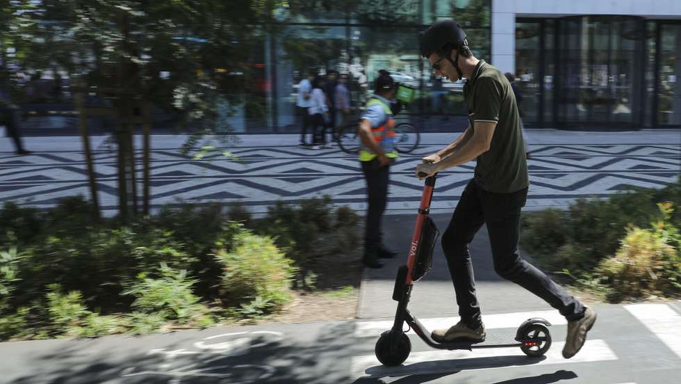 Um popular passa de trotinete a usar o capacete no dia do lançamento da campanha nacional “Não sejas Alberto, usa capacete!”, uma ação de sensibilização onde são demonstrados os efeitos de não usar capacete na condução de bicicletas e trotinetes na via pública. Lisboa, 28 de agosto de 2019. MIGUEL A. LOPES/LUSA