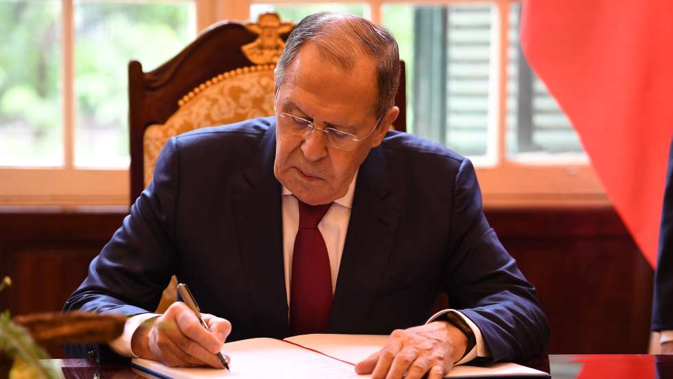 epa10054297 Visiting Russian Foreign Minister Sergey Lavrov signs a guestbook at the Government Guest House in Hanoi, Vietnam, 06 July 2022.  EPA/NHAC NGUYEN / POOL