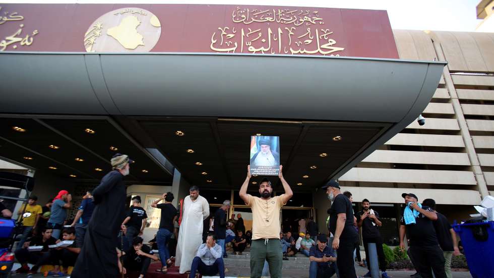 epa10106460 Supporters of Iraqi Shiite cleric Muqtada al-Sadr, head of the Sadrist movement, gather at the gate of Iraqi parliament building in the so-called 'Green Zone' in central Baghdad, Iraq, 04 August 2022. Thousends of the popular Shiite cleric Muqtada al-Sadr are still gathering inside the Iraqi parliament building in the heavily fortified Green Zone, home to government buildings and foreign embassies in Baghdad, protesting against a premiership candidate announced by the Shiite Coordination Framework, while the Iraqi Prime Minister called on supporters of the Sadrist movement to withdraw from the Iraqi parliament building.  EPA/AHMED JALIL